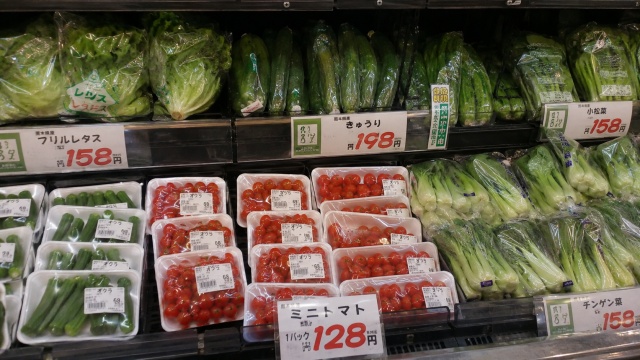 白プラ容器に入って売り場に並ぶ地場野菜とミニトマト