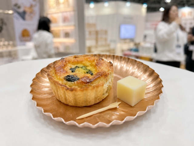 ピンクゴールドの紙製ミニトレーにキッシュとチーズを盛り付け、ピックを添えた状態
