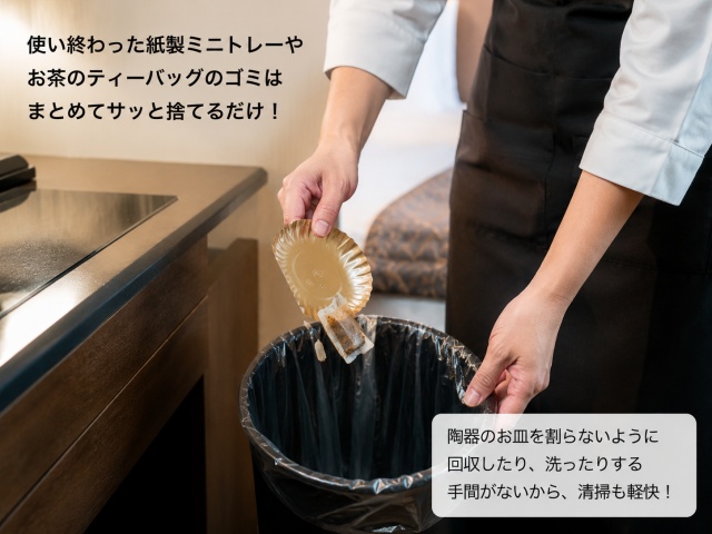 使用済みの紙製ミニトレーをゴミとして処理する客室清掃スタッフの手元