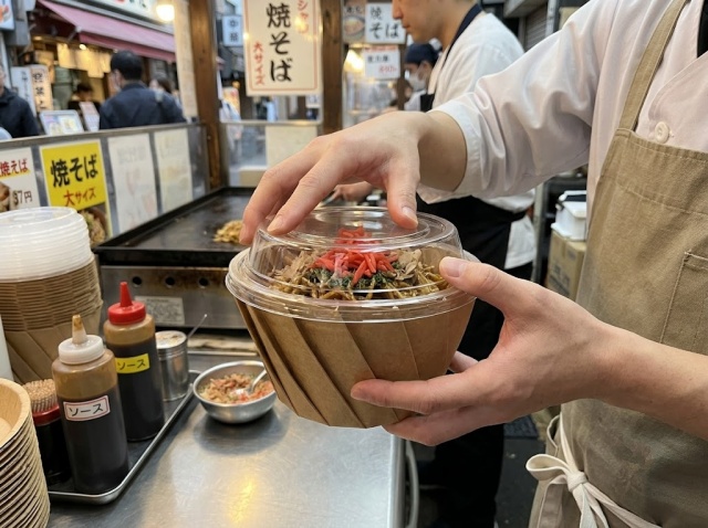 焼きそば容器の蓋がしっかり閉まるか確認している様子