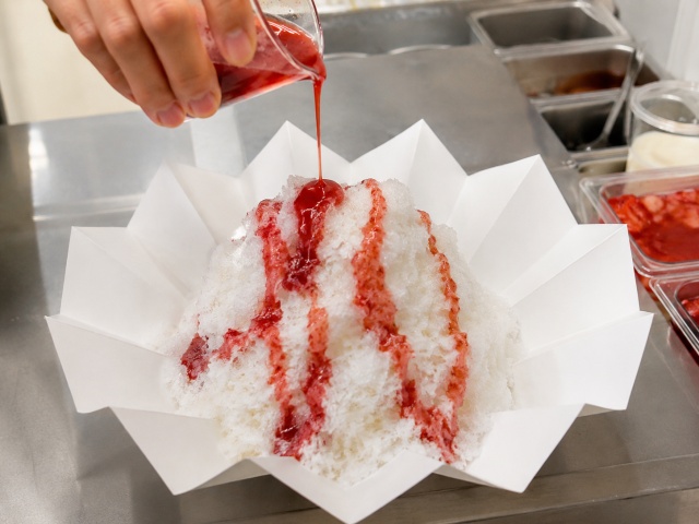 かき氷の側面にシロップを細く流している様子